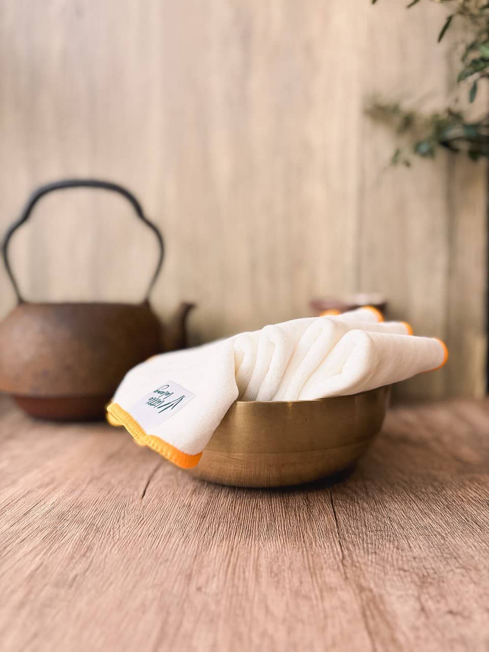 thick face towels in a bowl on a wooden table