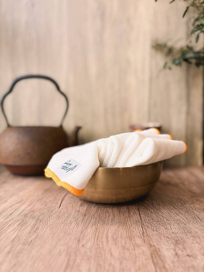 thick face towels in a bowl on a wooden table
